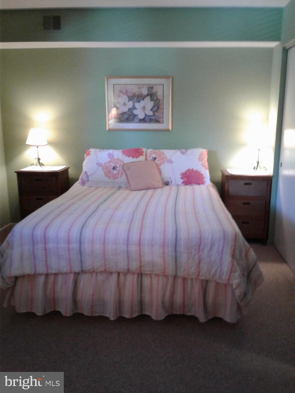 5717 Harpers Farm Road, Unit E Columbia, MD 21044 - Photo 18 of 21 a bed sitting in a bedroom next to a lamp