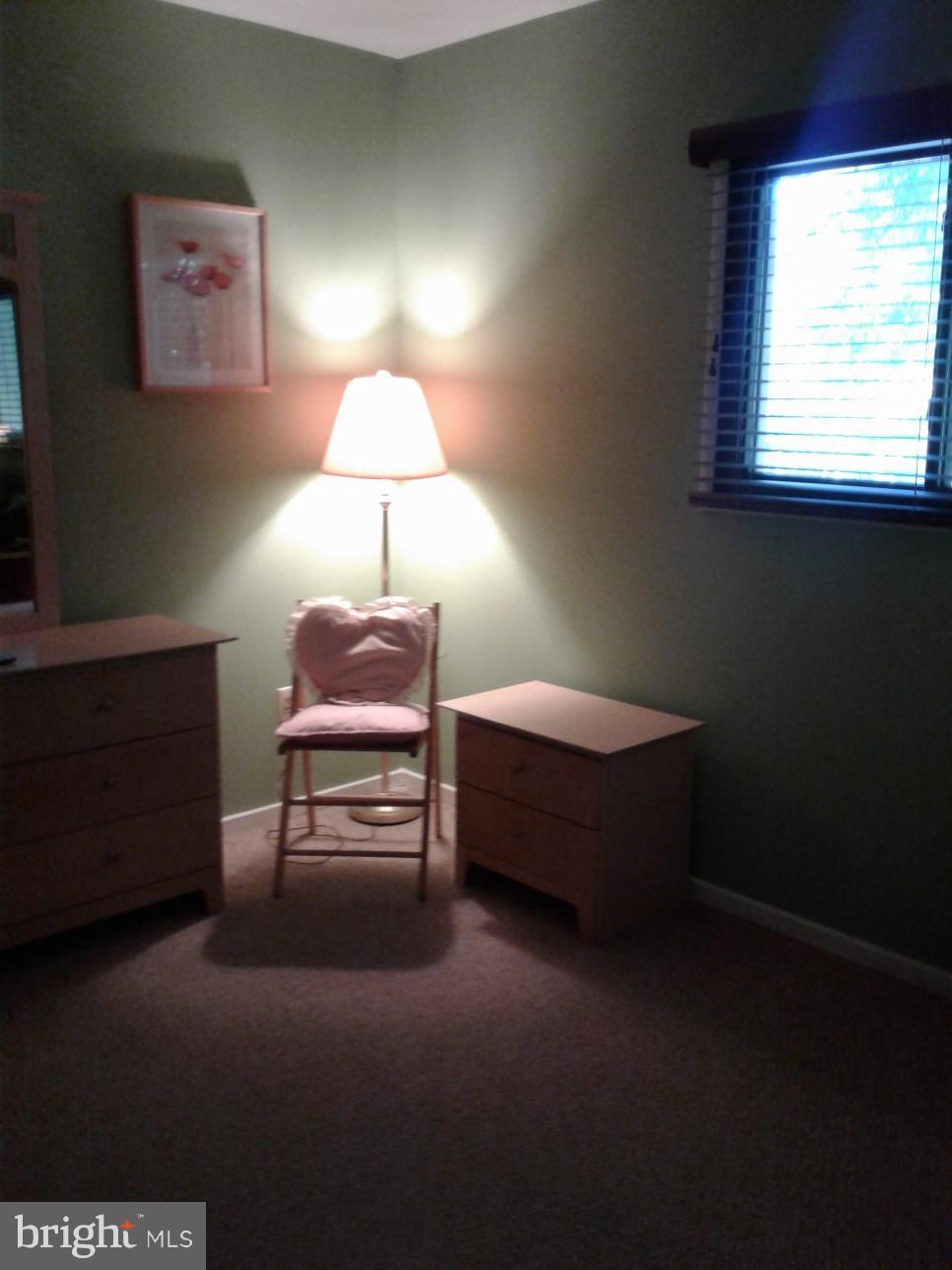 5717 Harpers Farm Road, Unit E Columbia, MD 21044 - Photo 20 of 21 a bedroom with a bed and a lamp on the dresser