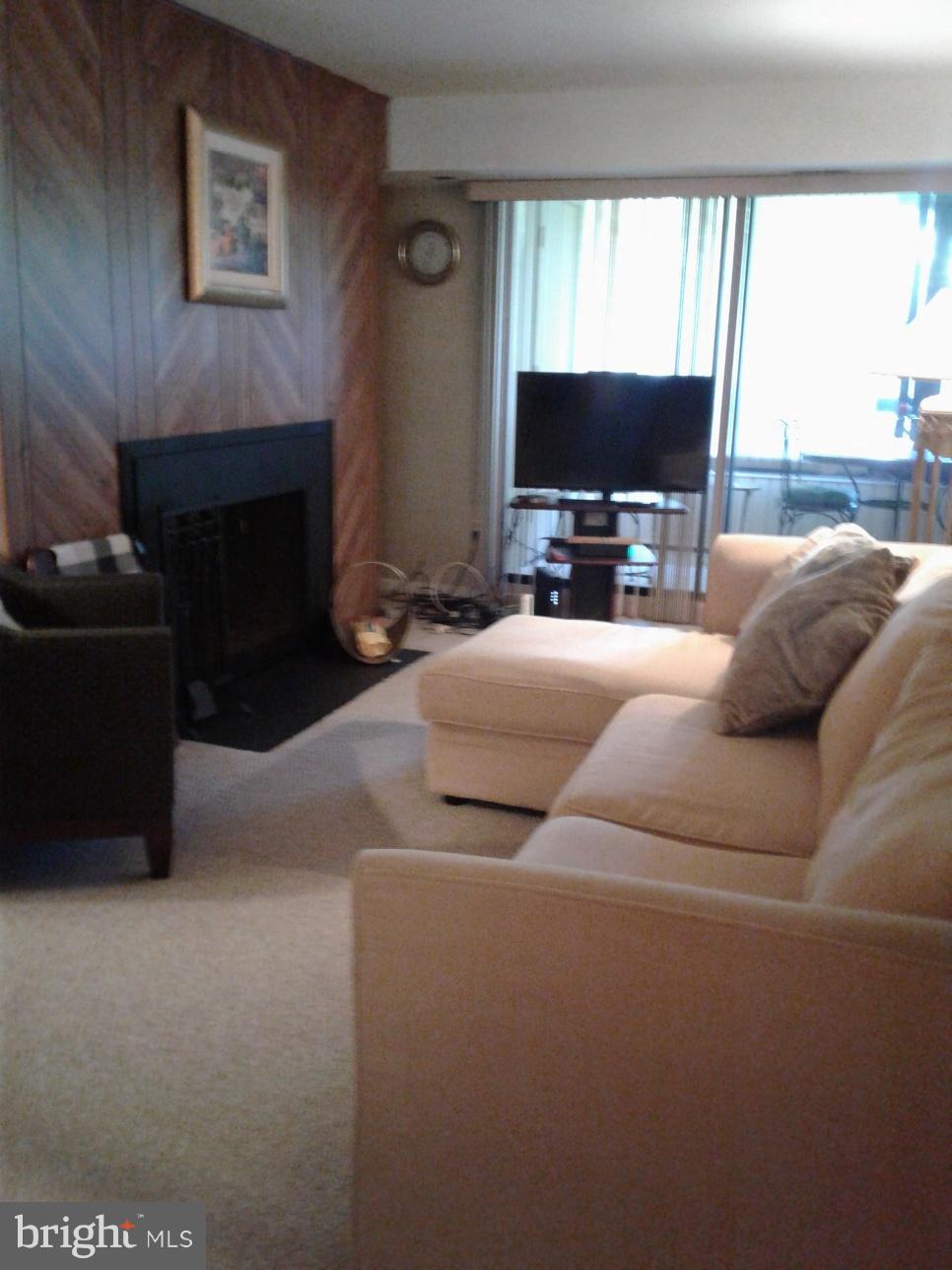 5717 Harpers Farm Road, Unit E Columbia, MD 21044 - Photo 8 of 21 a living room with furniture a flat screen tv and a fireplace