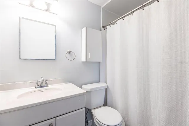 a bathroom with a sink a toilet and a mirror