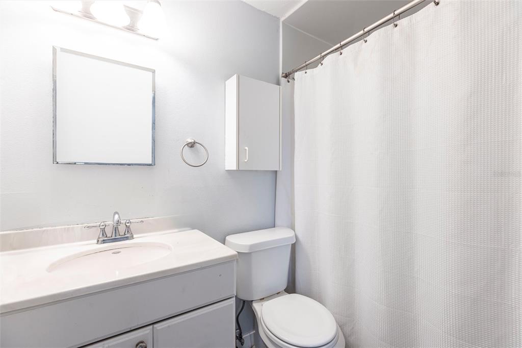 2345 Outrigger Lane Naples, FL 34104 - Photo 17 of 37 a bathroom with a sink a toilet and a mirror