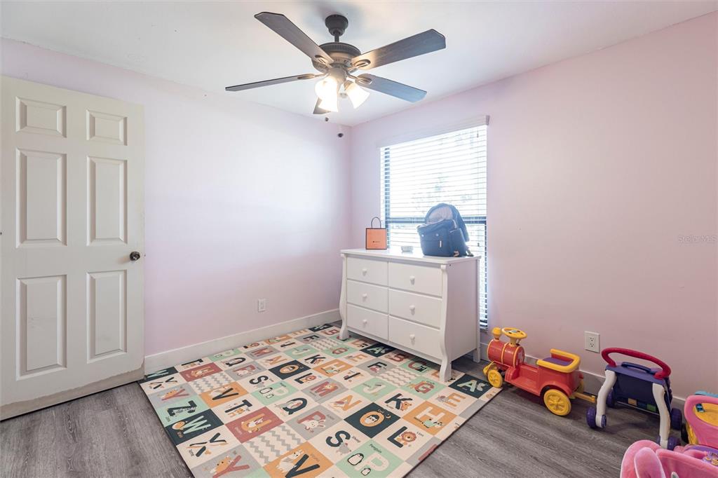 2345 Outrigger Lane Naples, FL 34104 - Photo 19 of 37 a bedroom with a bed and wooden floor