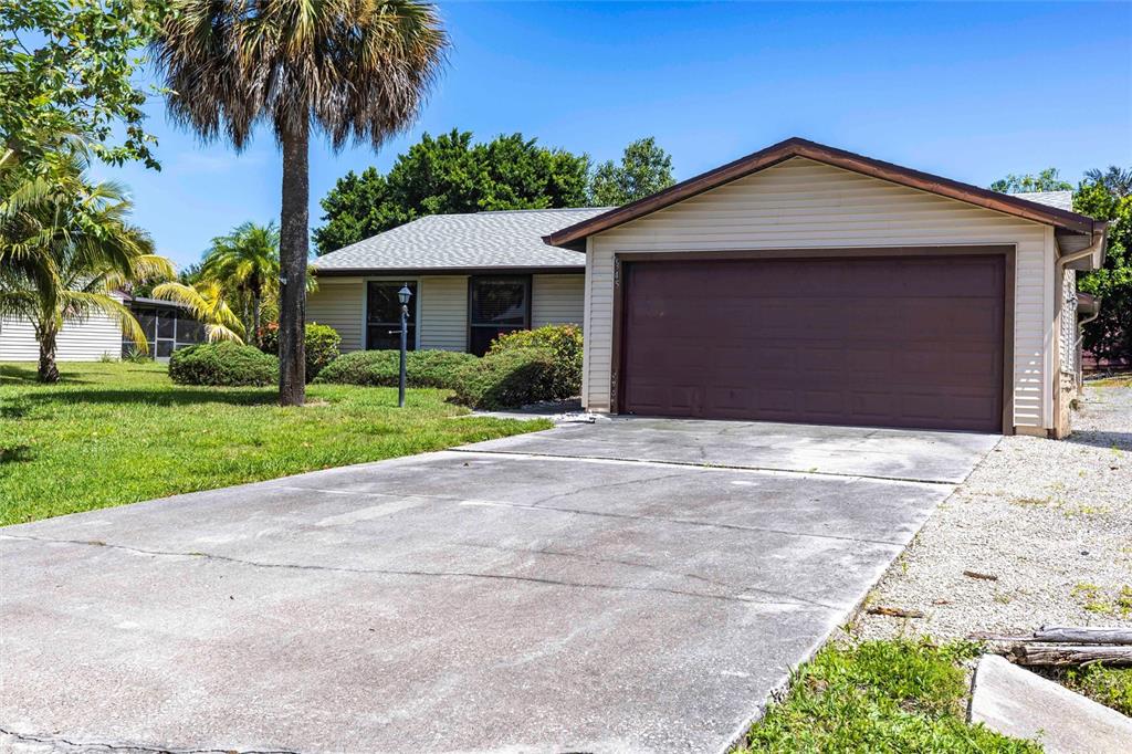 2345 Outrigger Lane Naples, FL 34104 - Photo 2 of 37 a front view of a house with a yard and garage