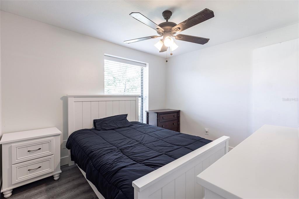 2345 Outrigger Lane Naples, FL 34104 - Photo 22 of 37 a bedroom with a bed and a chandelier