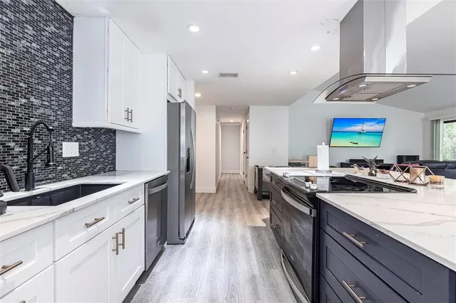 a kitchen with stainless steel appliances a sink stove and cabinets
