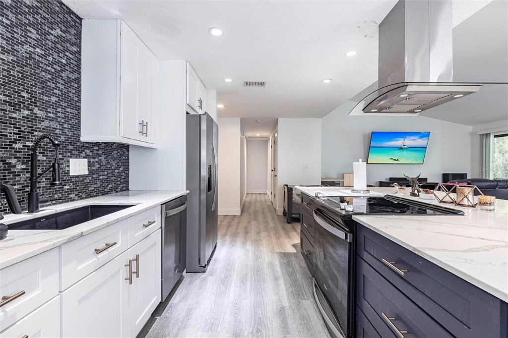 2345 Outrigger Lane Naples, FL 34104 - Photo 8 of 37 a kitchen with stainless steel appliances a sink stove and cabinets