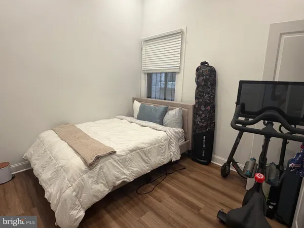 a bedroom with a bed and a flat tv screen on a dresser