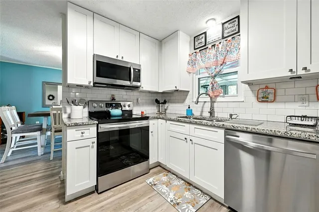 a living room with furniture a couch and large window with wooden floor