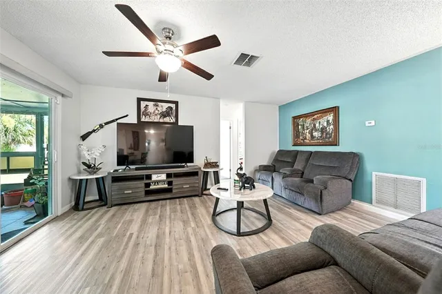 a spacious bedroom with a bed a dresser and potted plants on the dresser