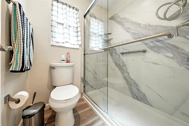 a bathroom with a toilet sink a mirror and window