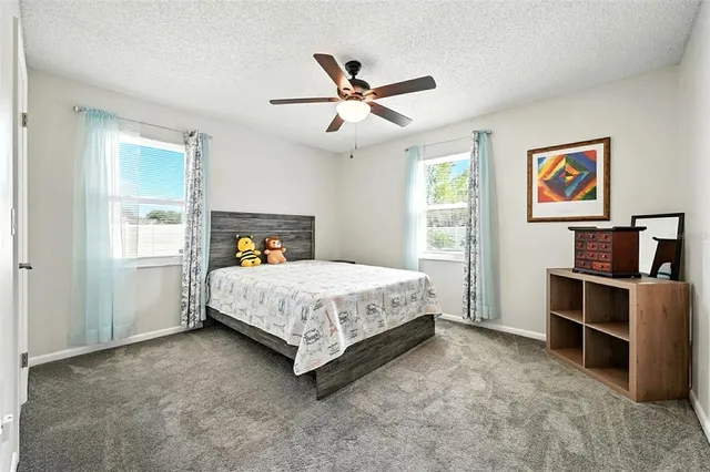 a living room with furniture a flat screen tv and a refrigerator