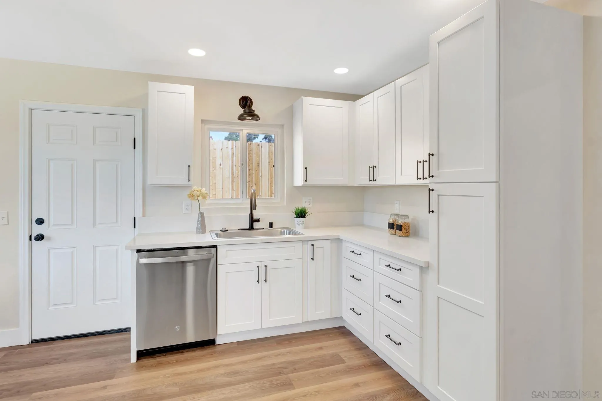 9188 Valencia Street Spring Valley, CA 91977 - Photo 17 of 27 a kitchen with white cabinets and sink