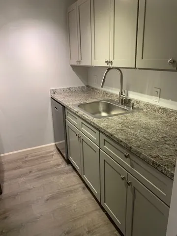 a kitchen with granite countertop a sink and cabinets