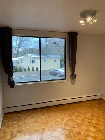 a view of a room with wooden floor and a window
