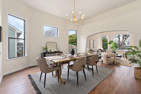 a kitchen with stainless steel appliances granite countertop wooden cabinets a stove a sink a dining table and chairs