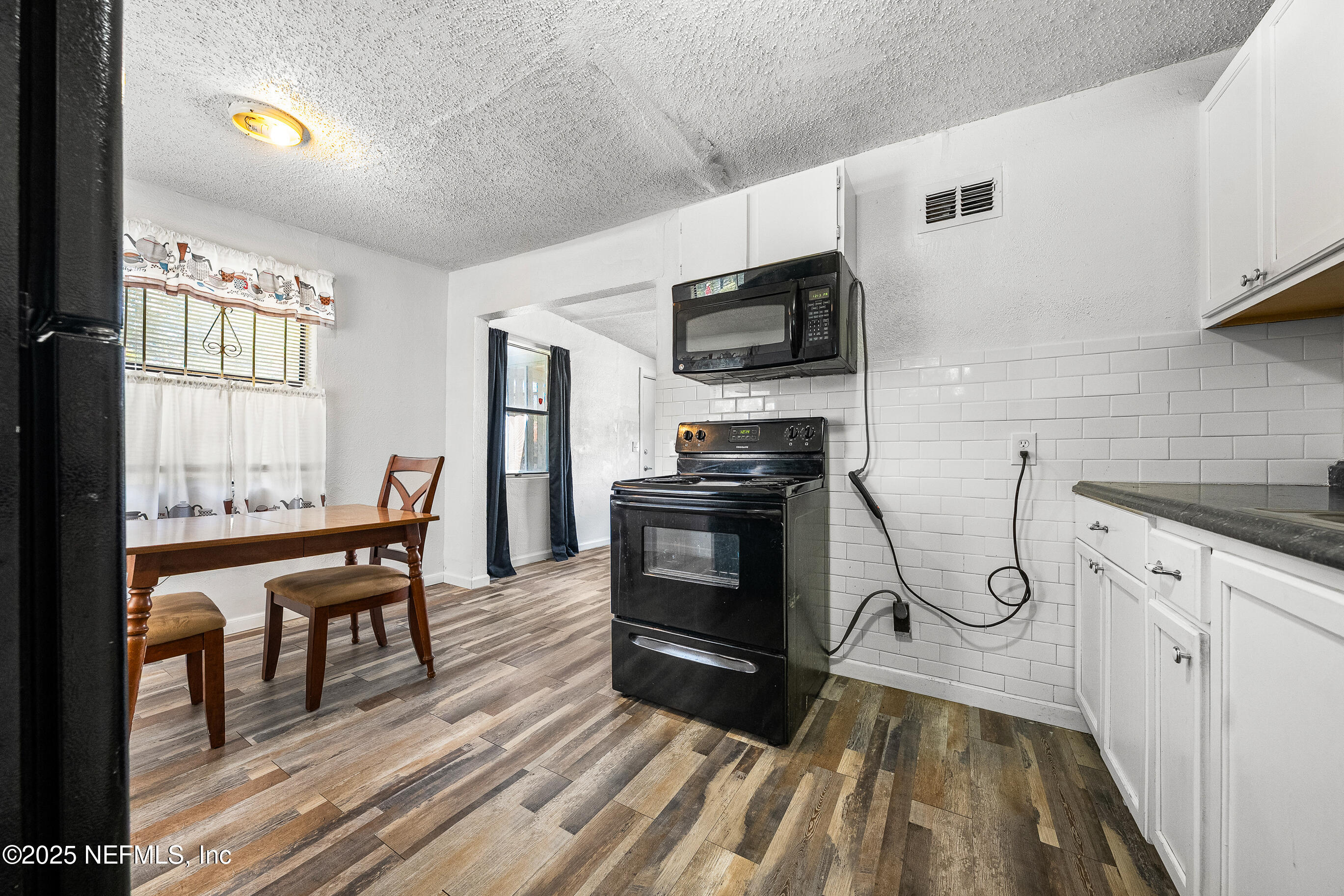 843 Line Street Jacksonville, FL 32209 - Photo 6 of 13 a kitchen with stainless steel appliances a stove a sink dishwasher a microwave oven and a dining table with wooden floor