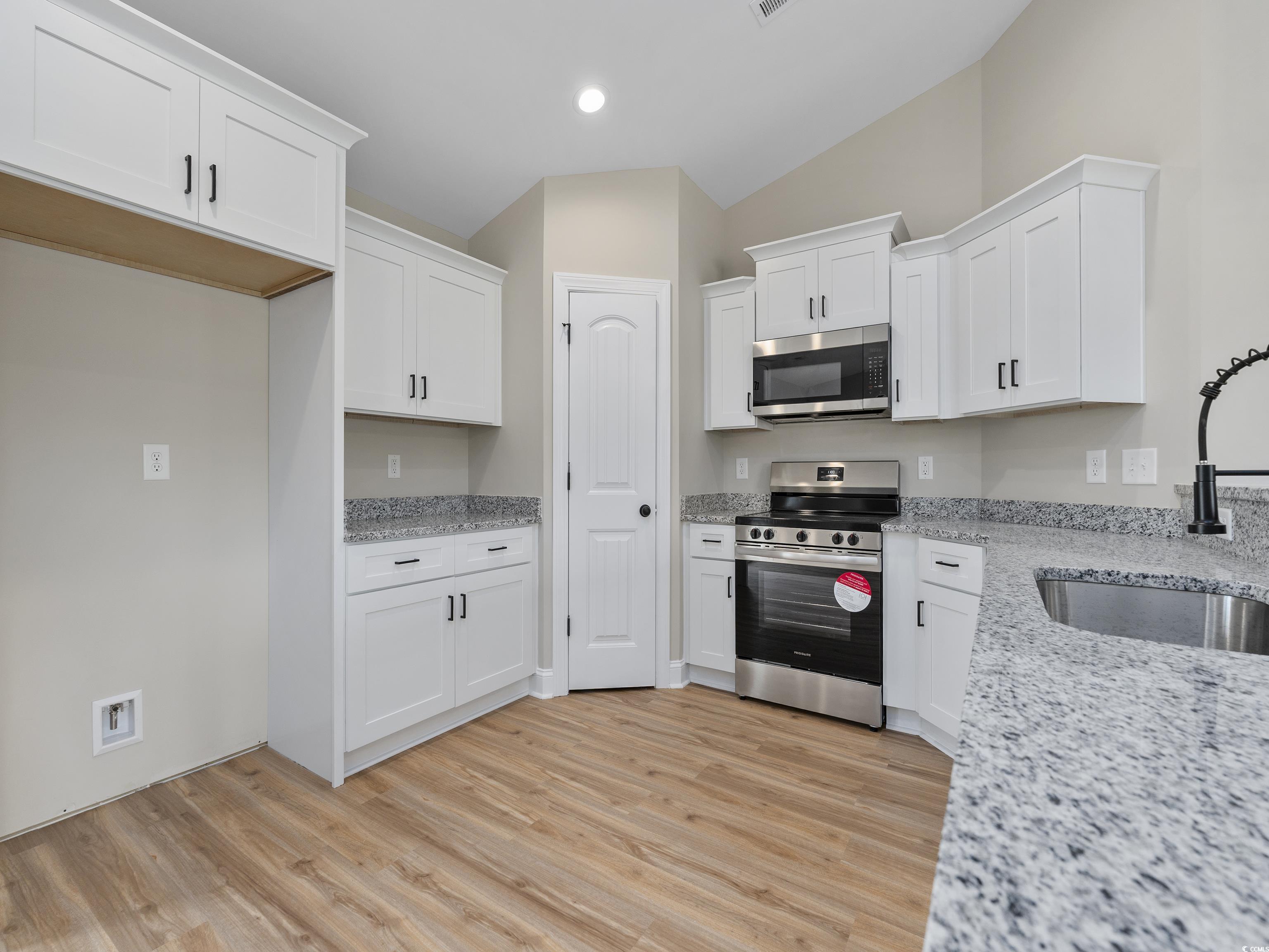 849 Highway 67 Loris Sc 29569 Loris, SC 29569 - Photo 9 of 28 Kitchen featuring stainless steel appliances, white cabinets, light wood-type flooring, and a sink