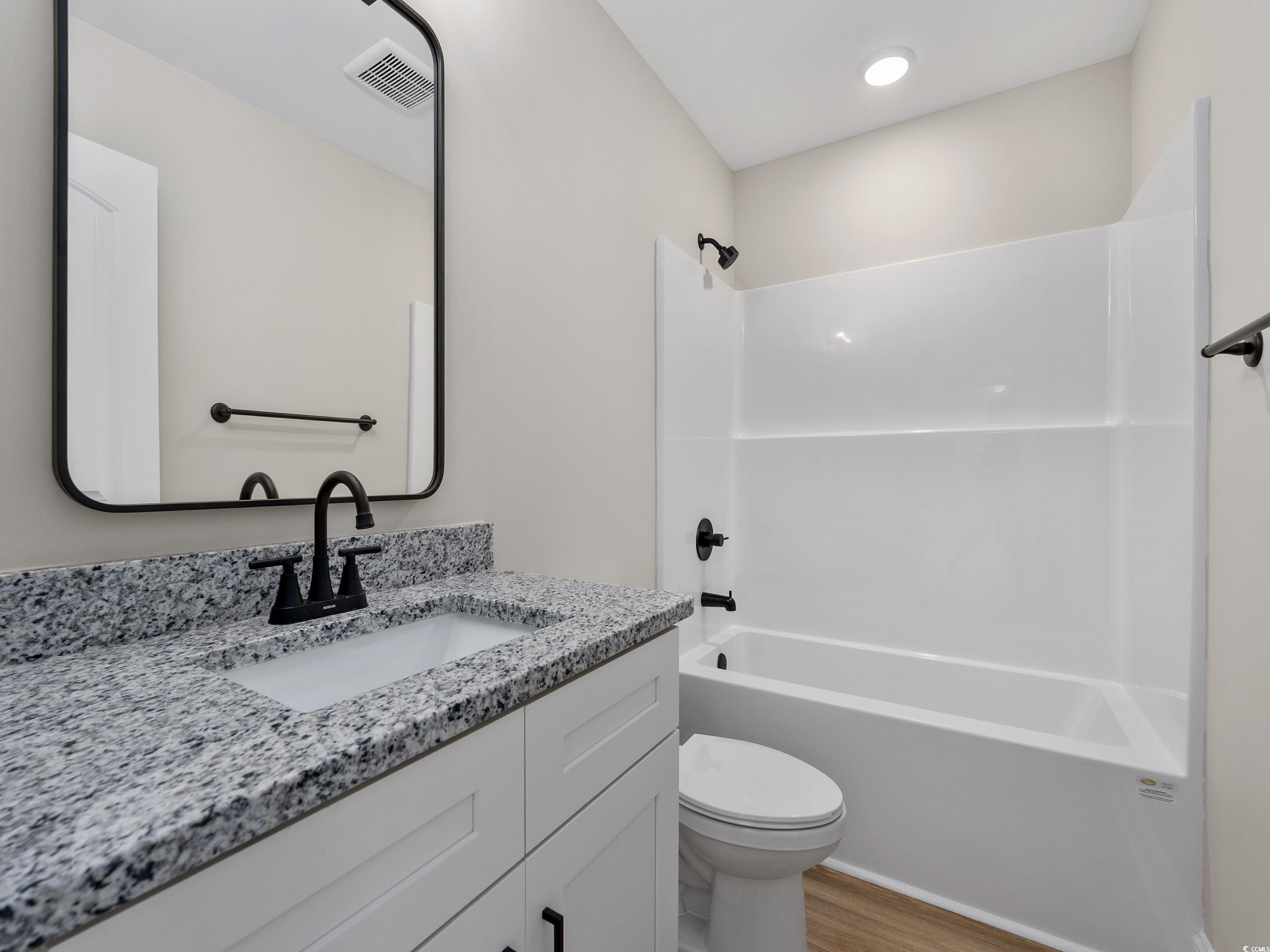 849 Highway 67 Loris Sc 29569 Loris, SC 29569 - Photo 20 of 28 Full bathroom featuring vanity, toilet, visible vents, shower / bathing tub combination, and wood finished floors