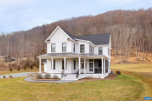 a front view of house with yard and trees in the background
