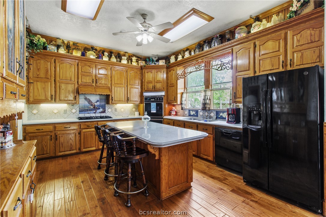 106 South Logan Avenue Bryan, TX 77803 - Photo 22 of 47 a kitchen with stainless steel appliances granite countertop a sink a stove and wooden floors