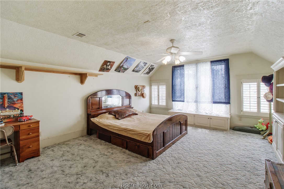 106 South Logan Avenue Bryan, TX 77803 - Photo 26 of 47 a spacious bedroom with a bed and a chandelier