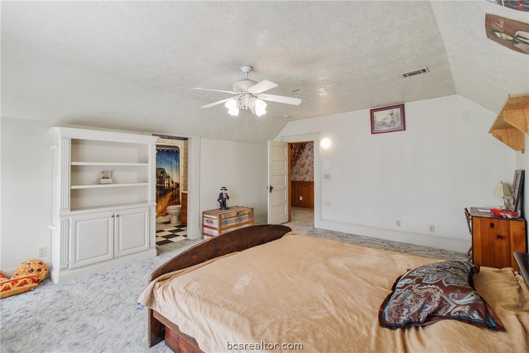 106 South Logan Avenue Bryan, TX 77803 - Photo 27 of 47 a bedroom with a bed and a chandelier