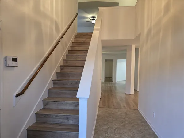 a view of staircase with white walls and white door