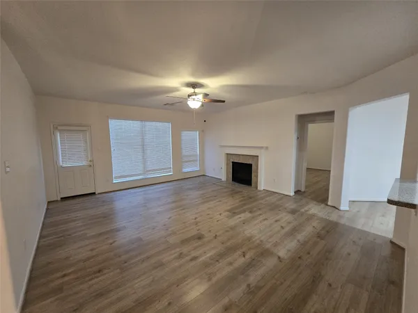 a view of an empty room with a fireplace and a window