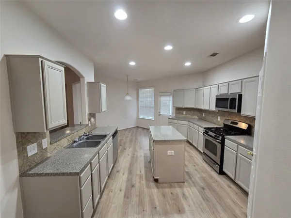 a kitchen with stainless steel appliances granite countertop a sink stove and refrigerator