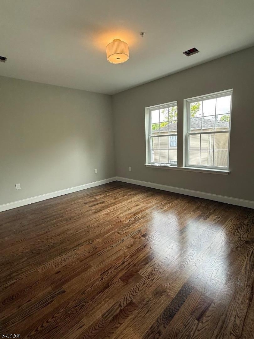 223 South 11th Street, Unit 2 Newark, NJ 07107 - Photo 11 of 15 an empty room with wooden floor and windows