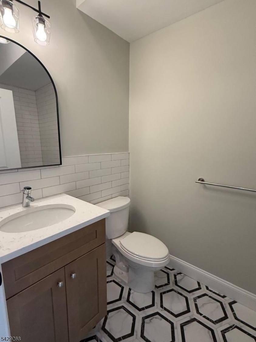 223 South 11th Street, Unit 2 Newark, NJ 07107 - Photo 14 of 15 a bathroom with a toilet a sink and mirror