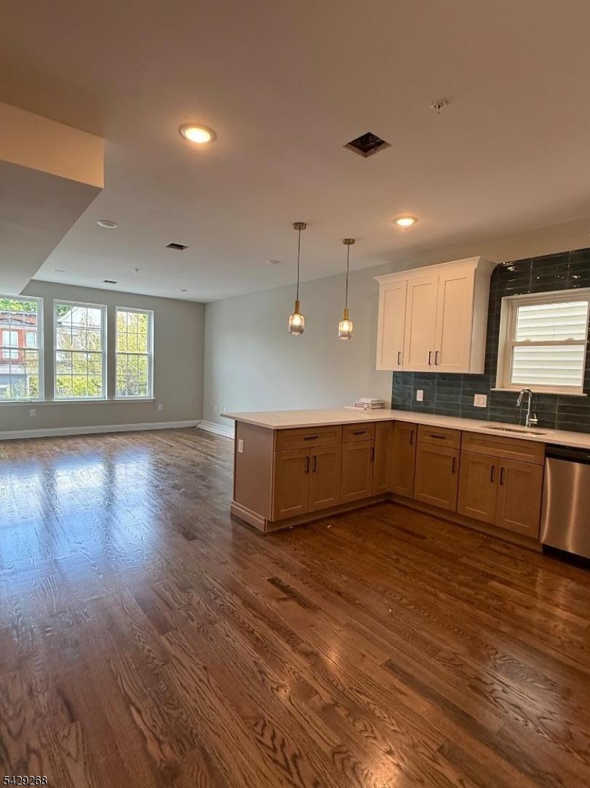 223 South 11th Street, Unit 2 Newark, NJ 07107 - Photo 5 of 15 a large kitchen with stainless steel appliances granite countertop a stove and a wooden floors