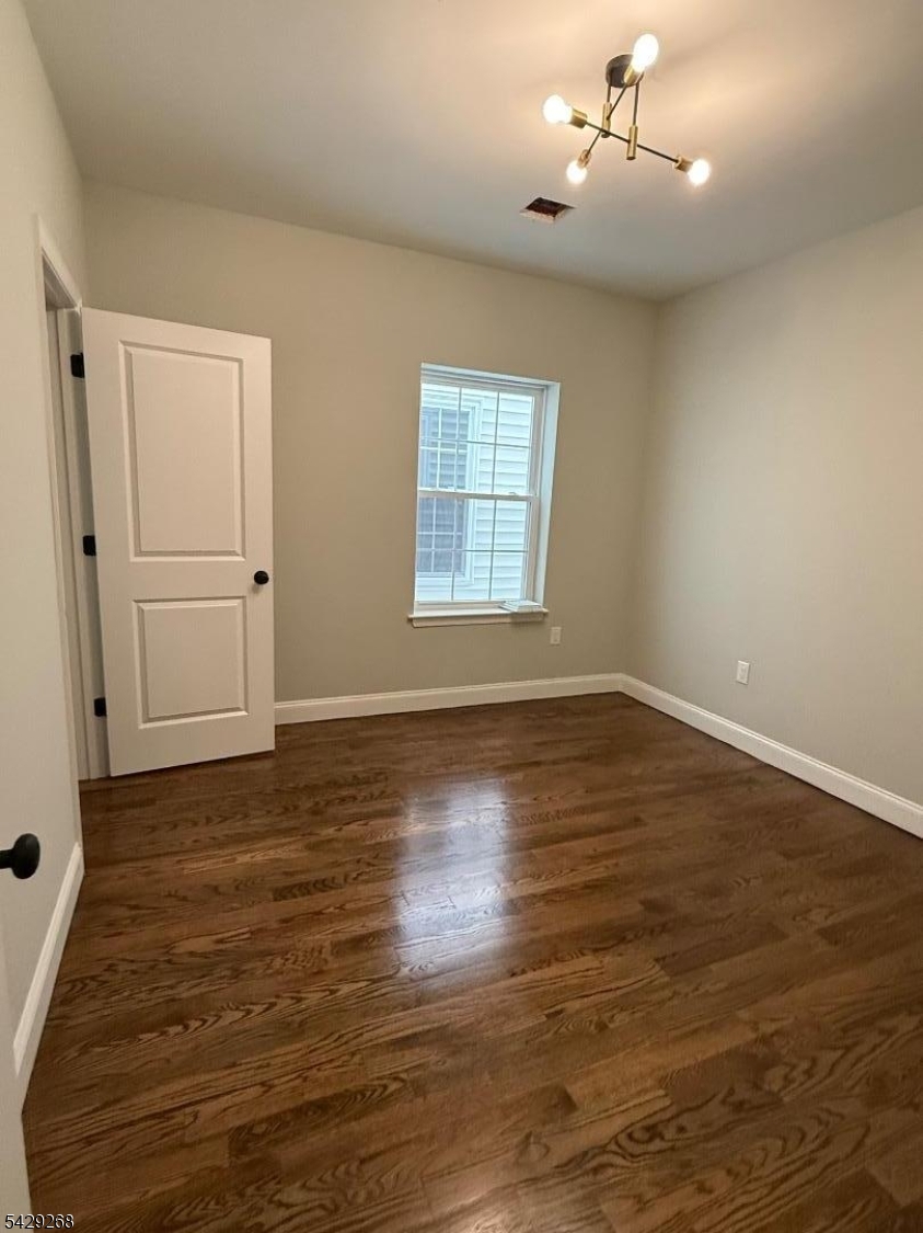 223 South 11th Street, Unit 2 Newark, NJ 07107 - Photo 10 of 15 an empty room with wooden floor chandelier fan and windows