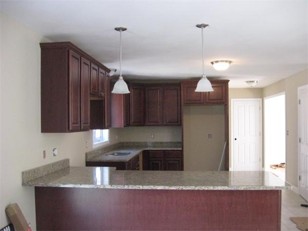 1328 Mammoth Road Pelham, NH 03076 - Photo 3 of 16 a kitchen with stainless steel appliances granite countertop a sink a stove and a refrigerator