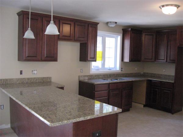 1328 Mammoth Road Pelham, NH 03076 - Photo 4 of 16 a kitchen with kitchen island granite countertop a sink a counter top space and cabinets