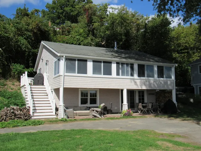 a view of a house with a yard and sitting area