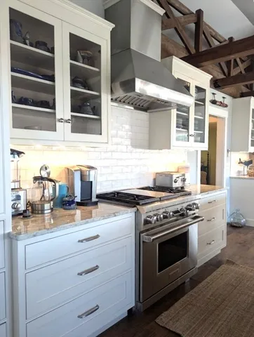 a kitchen with granite countertop stainless steel appliances stove top oven and cabinets