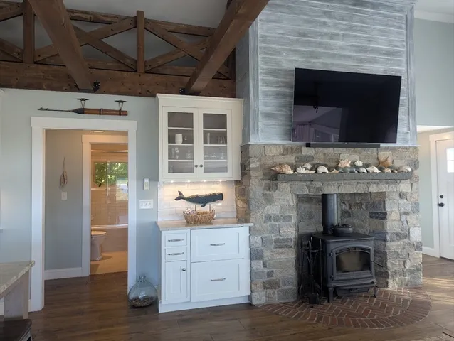 a kitchen with a fireplace and wooden floor