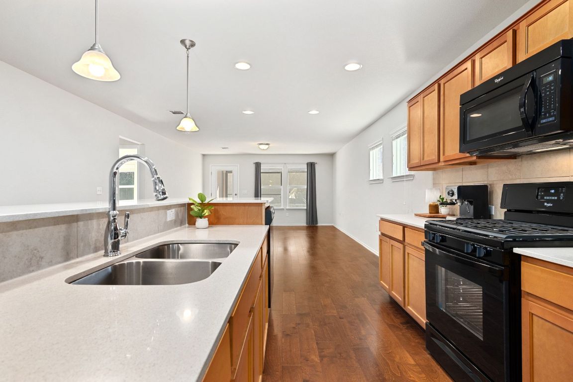 225 Hobby Street Georgetown, TX 78633 - Photo 40 of 40 a kitchen with stainless steel appliances granite countertop a sink a stove and a wooden floors