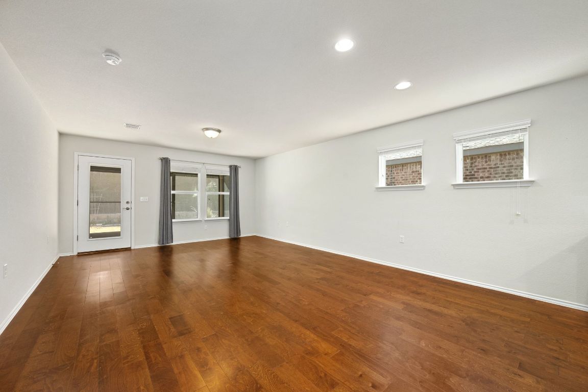 225 Hobby Street Georgetown, TX 78633 - Photo 12 of 40 a view of empty room with wooden floor and windows