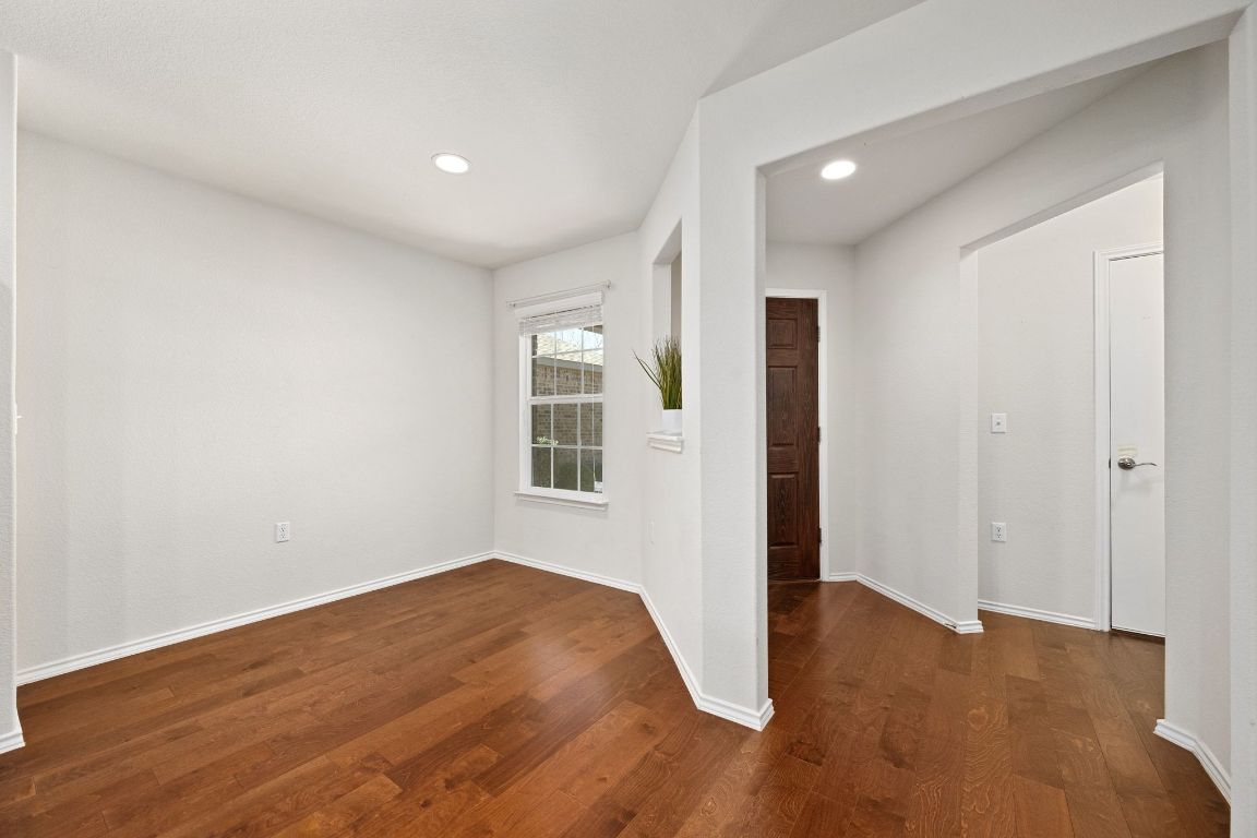 225 Hobby Street Georgetown, TX 78633 - Photo 6 of 40 an empty room with wooden floor and windows