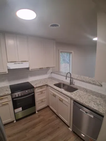 a kitchen with a sink stove and cabinets