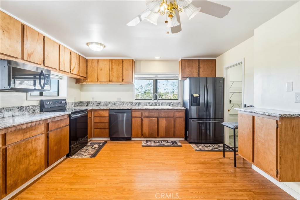 5975 Desert Star Road Johnson Valley, CA 92285 - Photo 12 of 74 a kitchen with stainless steel appliances granite countertop a refrigerator and a sink
