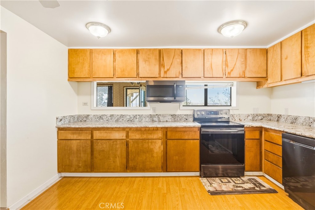 5975 Desert Star Road Johnson Valley, CA 92285 - Photo 13 of 74 a kitchen with stainless steel appliances granite countertop a stove a sink and a microwave