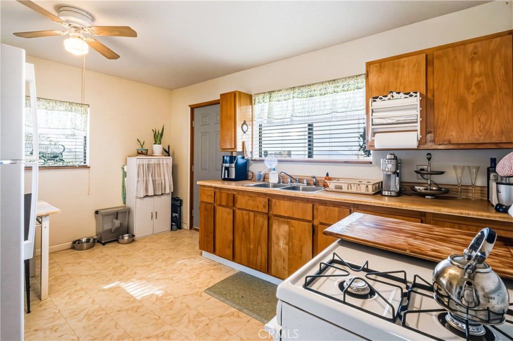5975 Desert Star Road Johnson Valley, CA 92285 - Photo 30 of 74 a kitchen with a stove a sink and a refrigerator