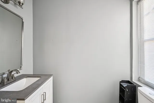 a bathroom with a granite countertop sink and a mirror