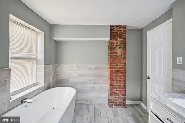 a bathroom with a bathtub a window and a shower