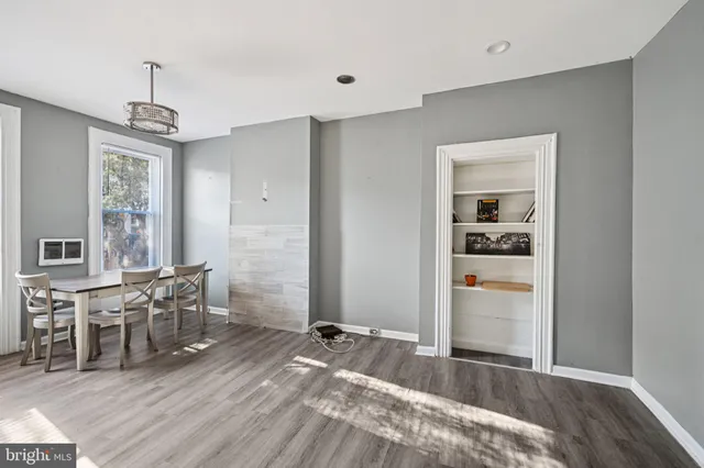 a view of a livingroom with furniture wooden floor chandelier and windows
