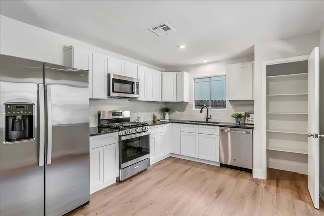 a kitchen with granite countertop stainless steel appliances and wooden cabinets