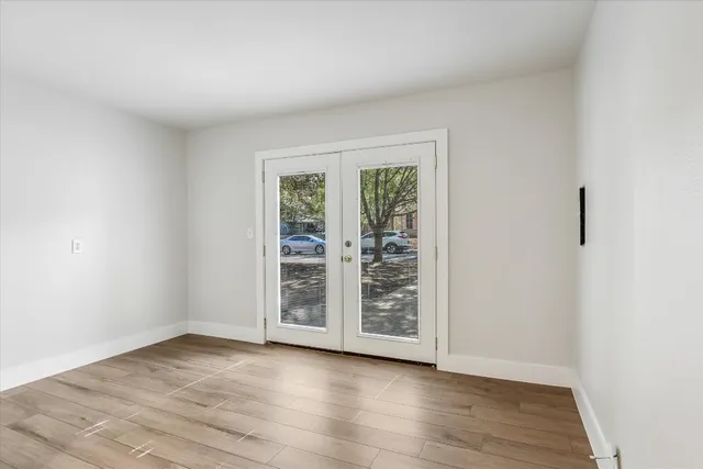 an empty room with wooden floor and window